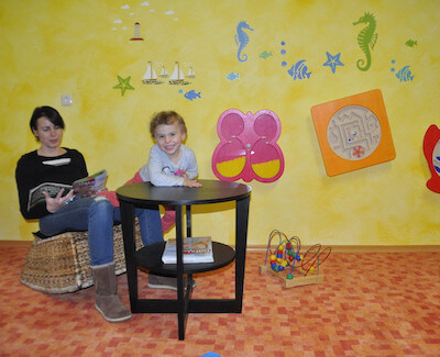 Kind mit Mutter im Spielezimmer im Feriendorf Schwarzholz